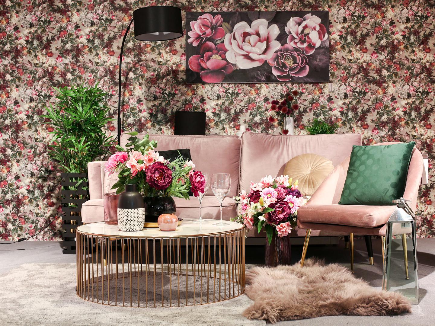Plišana sofa u atraktivnoj pink boji, zlatni detalji i moćna cvjetna tapeta izvrstan su izbor za ljubitelje atraktivnih prostora. Namještaj i detalji dostupni su u Emmezeti