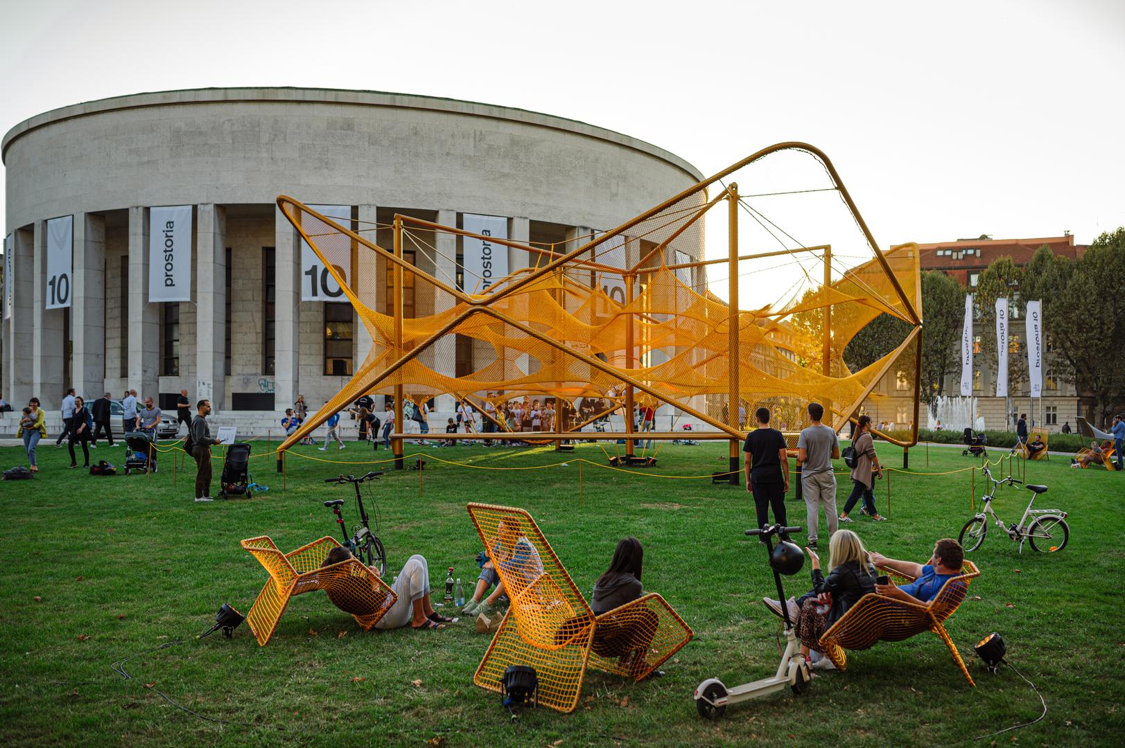 . Umjetnička instalacija Prostoria Net koja se poput velikog urbanog namještaja prostire na travnjaku ispred Paviljona, poseban je dar građanima za druženje, a objeručke je prihvaćena od svih generacija kao dnevni boravak na otvorenom