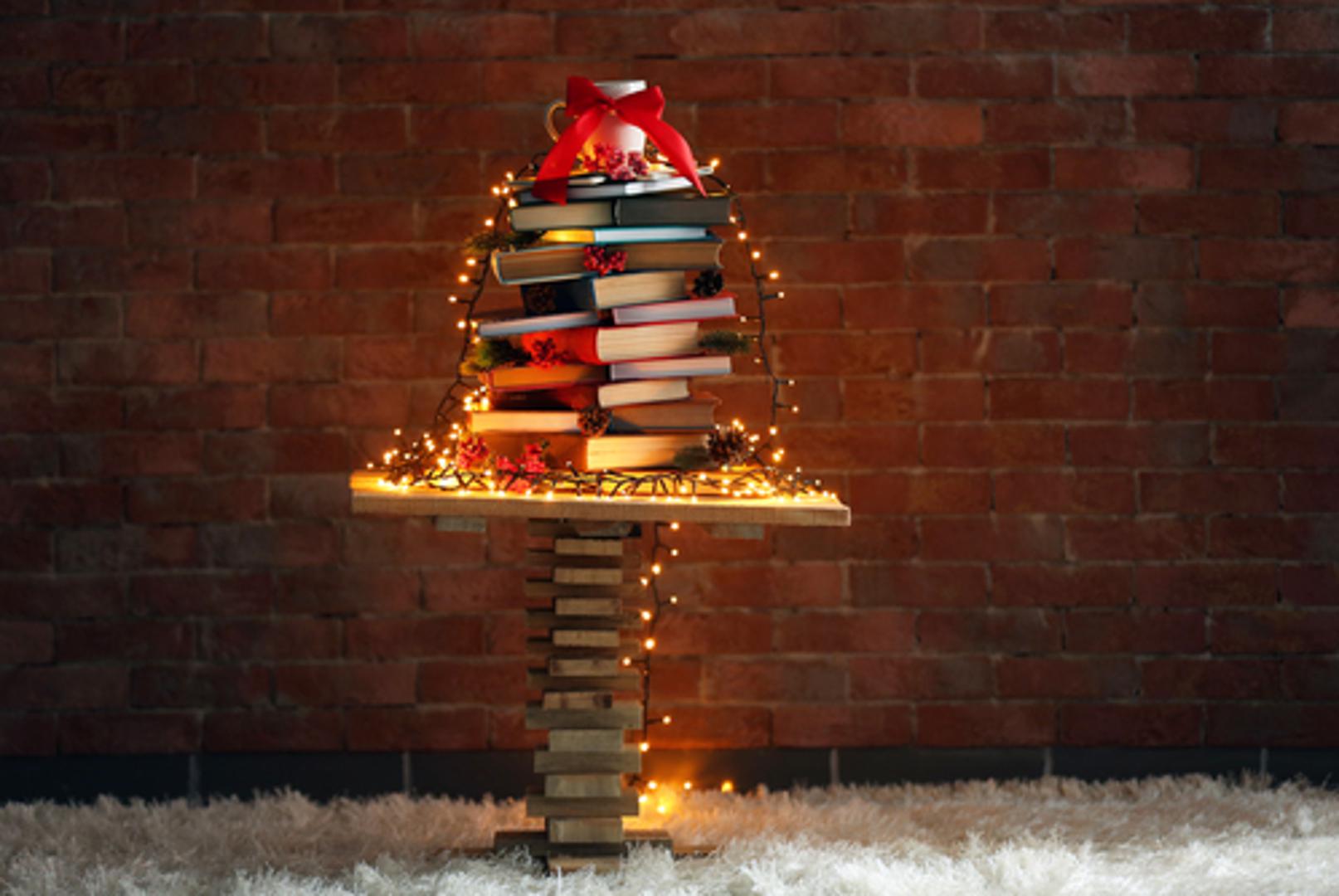 Jednostavno, a vrlo efektno rješenje jest knjige složiti u obliku bora i dodati im - lampice!